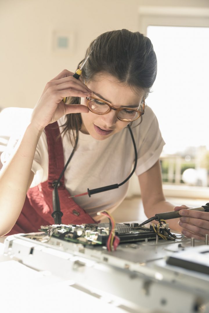Young woman working on computer equipment at home